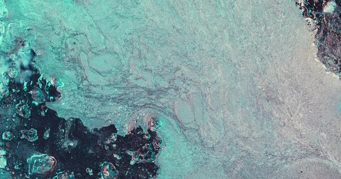 Ink water flow. Color liquid abstract background. Glitter fluid wave. Fluorescent blue pink shiny paint foam texture spill flat surface. Shot on RED Cinema camera.