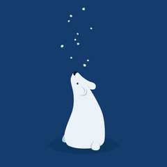 Cute polar bear looks at the falling snowflakes.