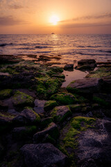 Boat in the distance during a warm summer sunset at the coast of Cyprus