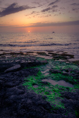 Boat in the distance during a warm summer sunset at the coast of Cyprus