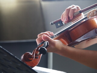 Close up hands of student on violin lesson in the room.