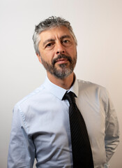 Portrait d'un homme d'affaires sympathique de 50 ans, souriant, portant une chemise et une cravate. Symbole de réussite professionnelle