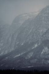 Mountain range with strong atmosphere during a snowy, dark winter afternoon