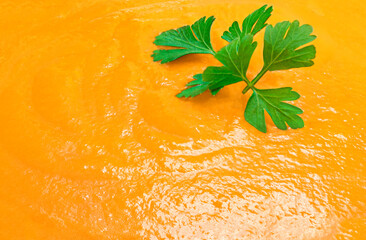 Pumpkin or Squash Cream soup texture as a background with parsley leaf. Autumn cream-soup Pattern,...