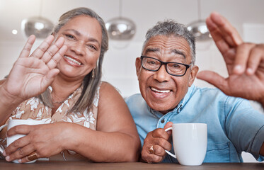 Senior couple, coffee and wave for video call smiling, talking or speaking at home. Elderly man and woman greeting on social media or face time while enjoying a warm beverage indoors