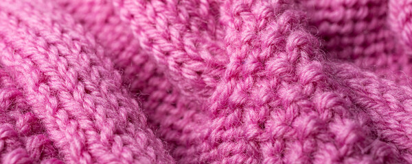 Background with knitting pink wool sweater with braid cable. Above overhead shot banner