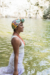 A young black woman in a river in nature scene