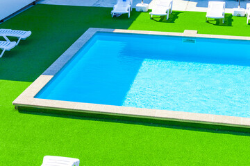 pool design in a modern residence. Sunny weather, sun beds. Vacation