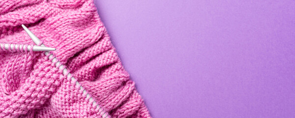 Banner with Knitting flat lay with pink wool yarn and knit accessories over lilac, top view, overhead shot with copy space