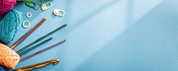 Crochet blue banner with cotton yarn, crochet hooks and accessories. Flat lay overhead shot with...
