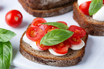 Delicious sandwich with mozzarella, fresh tomatoes and basil