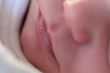 Fototapeta premium closeup of the lips of a tiny newborn baby asleep in his crib. selective focus