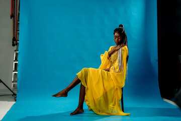 a girl in a yellow dress on a blue background