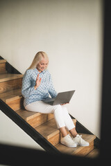 Joyous woman communicating with someone via Skype