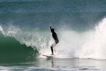 Surfing on high waves on the Mediterranean Sea in northern Israel.