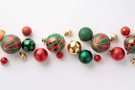 Christmas decorations concept. Top view photo of red green and gold baubles balls on isolated white background