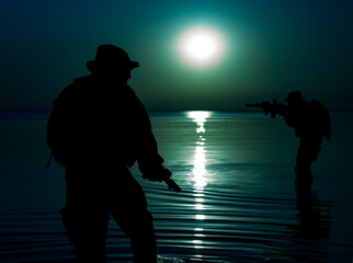 Army soldiers with rifles moon night silhouette in action during raid crossing river in the water, two militants with rifles at night