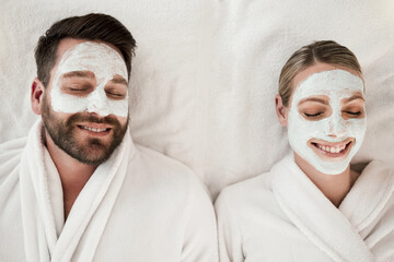Skincare, spa and face mask with relax couple smile, happy and luxury cosmetic treatment together from above. Man and woman skincare, beauty and wellness at a health clinic for relaxation body care