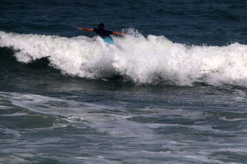 Surfing on high waves on the Mediterranean Sea in northern Israel.