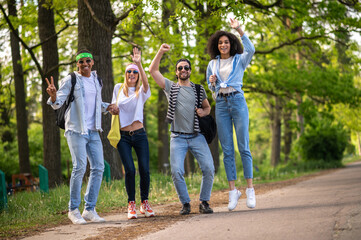 Young tourists hitchhiking on the forest road