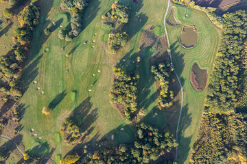 Aerial view of a big golf course, beautiful green grass, field and trees in autumn