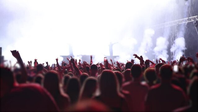 Dark stage of DJ music concert blowing by shiny colorful lights flashing and smoke 