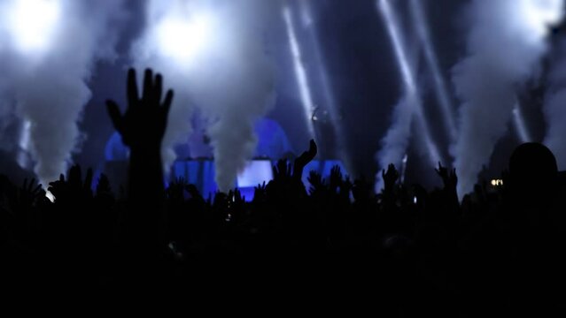 Silhouette hands of audience crowd people enjoying the concert, cheering clapping hands 