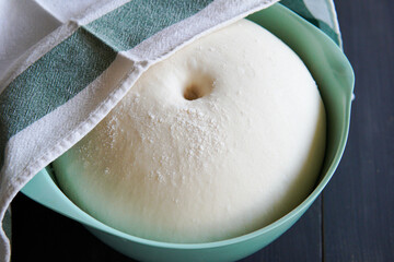 Bowl of yeast dough covered with cloth.