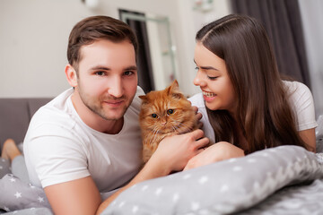 Obraz premium Happy sensual young couple lying in bed together
