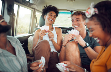 Friends, car road trip and game of card for diversity group of people bond and enjoy quality...