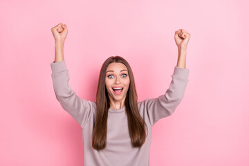 Portrait of overjoyed glad lady raise fists attainment scream yeah isolated on pink color background