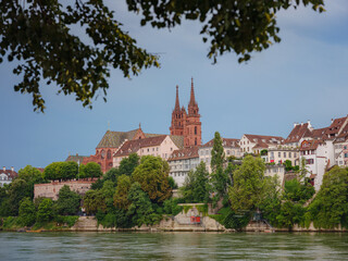 Fototapeta na wymiar Buildings in the city centre of Basel and the Rhine river, Switzerland. Riverside of swiss city with Basel Cathedral