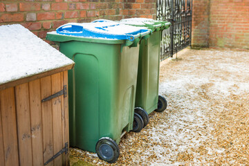 Wheelie bins in a garden covered in snow in winter, UK