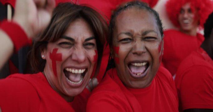 Latin red sport fans screaming while supporting their team - Football supporters having fun at competion event - Champions and winning concept