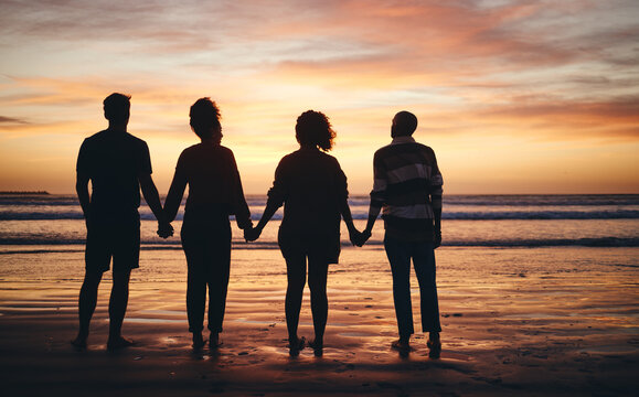 Silhouette, friends and beach sunset holding hands in freedom, support and calm peace in nature together. Back shadow fun couples group relax, summer ocean horizon and tropical vacation in solidarity