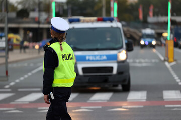 Policjantka z lizakiem do zatrzymywania pojazdów kontroluje ruch drogowy.  - obrazy, fototapety, plakaty