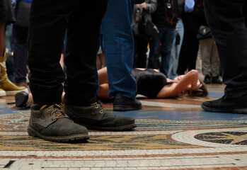 woman lying in the floor and men around her - concept abuse, submission, woman rights and sexual...