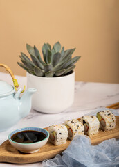 Sushi roll and green tea on a white table. portrait image