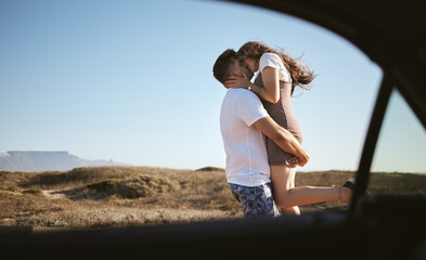 Kiss, love and couple on road trip with car in nature of California together during summer. Young man and woman kissing while on travel holiday with transport in the countryside for adventure
