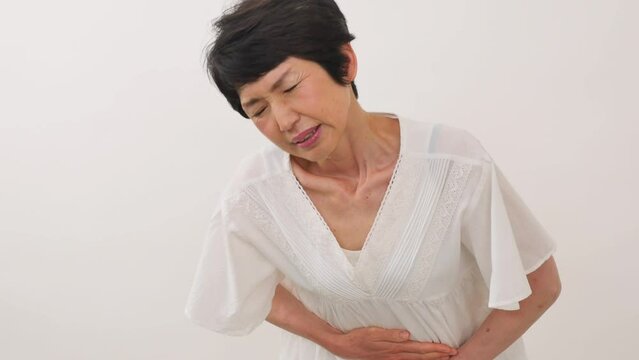白背景で腹痛の中年女性