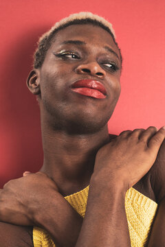 A portrait of an androgynous black guy on a red background. LGBTI concept