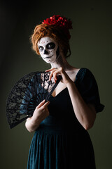 Elegant scary halloween costume. Mexican Day of the Dead Tradition. Skull with flowers makeup for a party. Party ideas. Mysterious portrait of a woman with a painted face. scary face. 