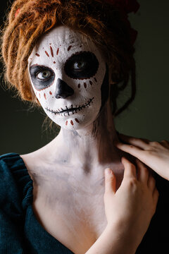 Elegant scary halloween costume. Mexican Day of the Dead Tradition. Skull with flowers makeup for a party. Party ideas. Mysterious portrait of a woman with a painted face. scary face. dark background