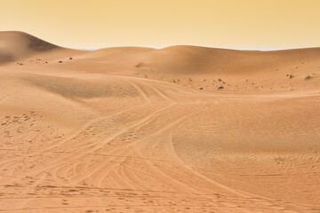 Landscape photo of desert and sand dune under the golden hour sunset sky in Dubai, UAE