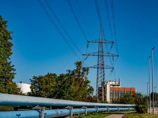 Strommasten und Fernwärme Rohre vom Heizkraftwerk