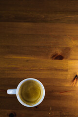 White cafe latte cup on wooden table with black background. Product. Vertical Photography