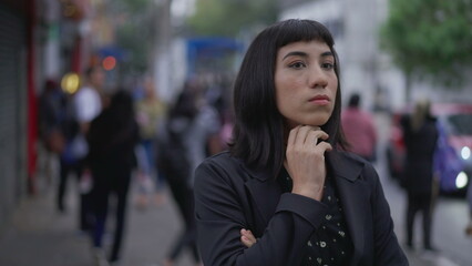 Fototapeta premium One anxious young hispanic woman standing in street feeling worry and anxiety. Businesswoman latina late waiting while feeling angst and preoccupation