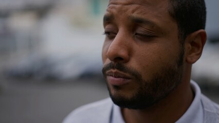 Obraz premium One anxious young African American man in distress closeup face. Portrait of a black person with worried preoccupied emotion