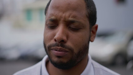 One anxious young African American man in distress closeup face. Portrait of a black person with worried preoccupied emotion