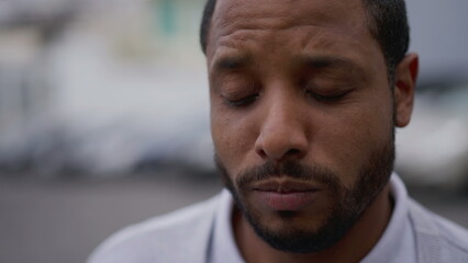 Obraz premium One anxious young African American man in distress closeup face. Portrait of a black person with worried preoccupied emotion